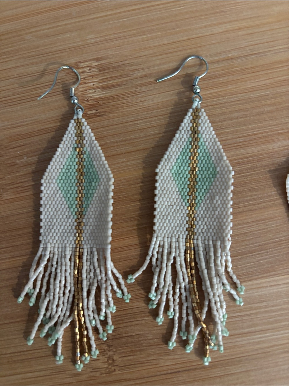 Ink + Alloy teal, gold, and cream fringe earrings.